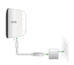 Ein Bild eines Arlo Security Light, das an das USB-Ladekabel angeschlossen ist, das an das Netzteil angeschlossen ist, das an eine Steckdose im Innenraum angeschlossen ist